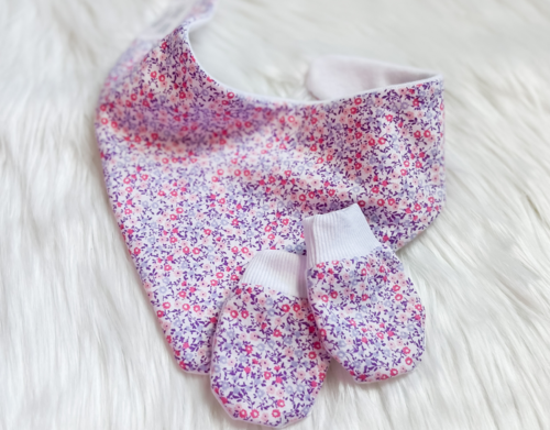 Floral-patterned baby bib and booties on a white background