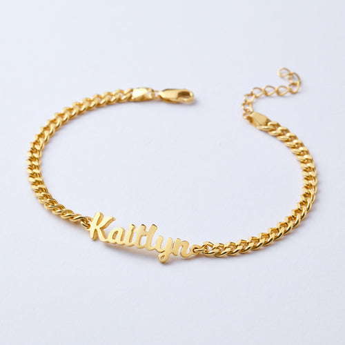 Gold chain bracelet with 'Kaitlyn' engraved on a light gray background