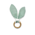 Green bunny ear teething ring with wooden ring on a white background