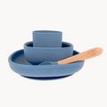 Blue silicone dinnerware set with wooden spoon on a white background